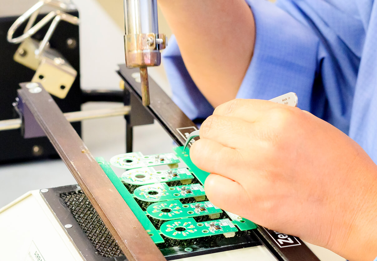 Rapier Electronics Adelaide - electronics manufacturing pic of a worker soldering a printed circuit board.